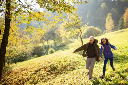 Female and male young active hikers have fun and run in the middle of the mountains. Man and a woman went on a mountain trip. Concept of adventure, travel and tourism.