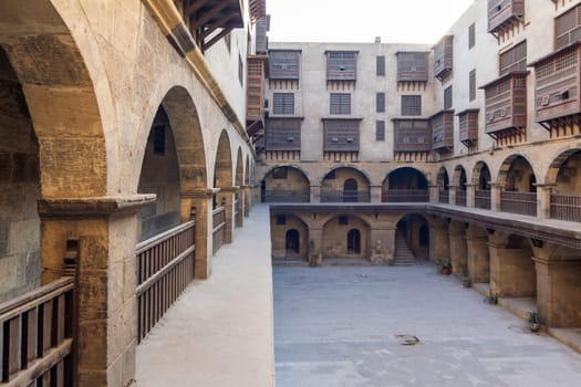 Facade of Caravanserai of Bazaraa, with vaulted arcades, windows, and arab oriel windows - mashrabiya - suited in Tombakshia street, Al Gamalia district, Medieval Cairo, Egypt