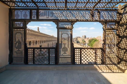 Passage surrounding the Mosque of Ibn Tulun framed by interleaved wooden perforated wall, Mashrabiya, Medieval Cairo, Egypt