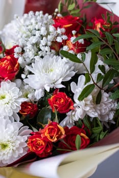 Floristics. Close up bouquet of pink roses, white chrysanthemums, gypsophila and sprigs of greenery. Concept of Women's Day, Mother's Day and Birthday.