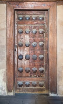 Grunge wooden aged door on grunge stone wall, Medieval Cairo, Egypt