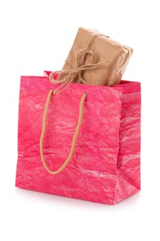 Pink nacre package with a gift box inside on a white background. Package is made of crepe paper. Concept of gifts for birthday, women's day, mother's day. Isolated on white. Isolated.