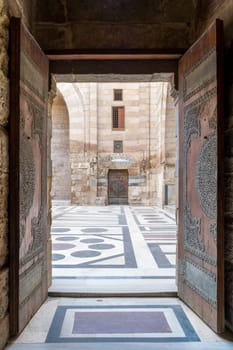 Opened door leading to the courtyard of Al-Sultan Al-Zahir Barquq mosque. Al-Moez Street, Old Cairo, Egypt