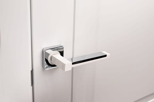 Door handles elements close up. Door handle on white closed doors in modern loft style in interior. Concept of accessories for interior design home interior of apartment or office.