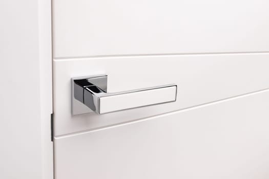 Door handles elements close up. Door handle on white closed doors in modern loft style in interior. Concept of accessories for interior design home interior of apartment or office.