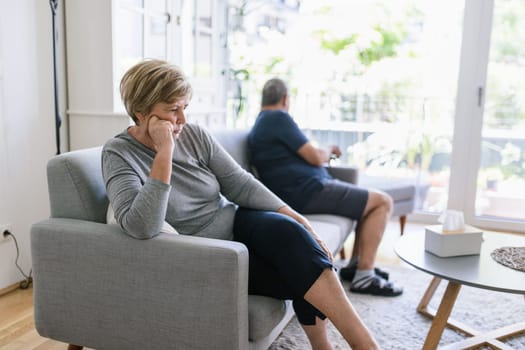 Upset senior couple at home in living room having an argument
