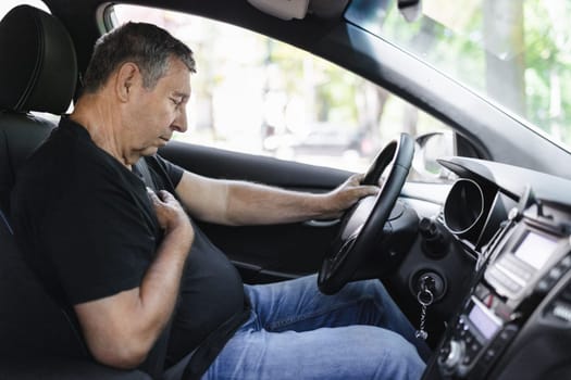 Senior in his 70s, behind the steering wheel with chest pain
