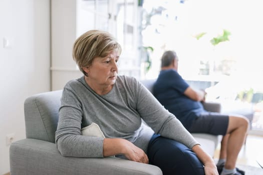 Upset senior couple at home in living room having an argument
