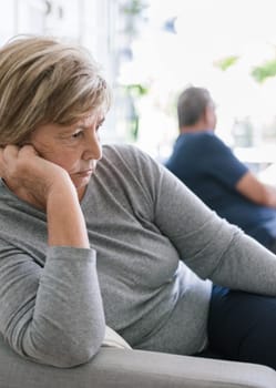 Upset senior couple at home in living room having an argument