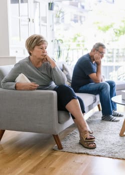 Upset senior couple at home in living room having an argument
