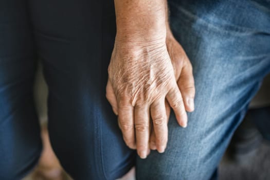 Happy romantic senior couple in love holding hands at home