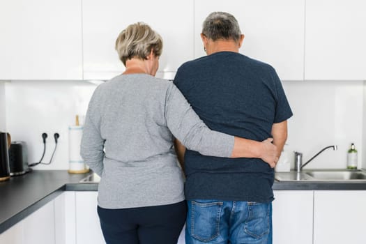 Happy romantic senior couple in love cooking together at home