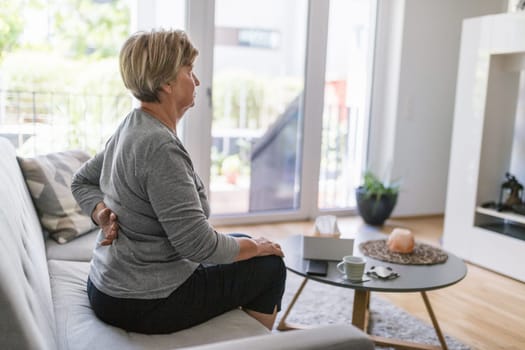 Elderly woman at home with lower back pain