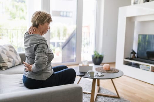 Elderly woman at home with lower back pain