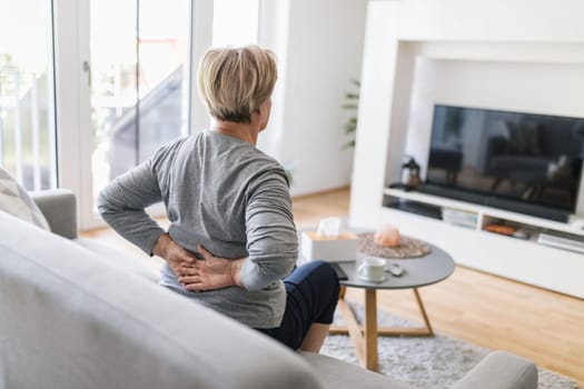 Elderly woman at home with lower back pain