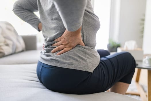 Elderly woman at home with lower back pain
