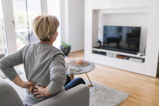 Elderly woman at home with lower back pain