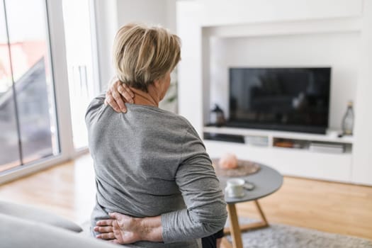 Elderly woman at home with lower back pain