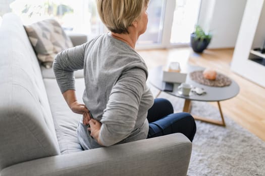 Elderly woman at home with lower back pain