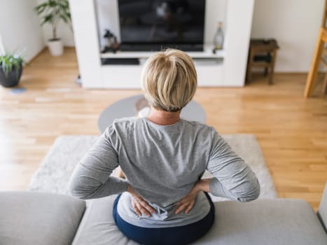 Elderly woman at home with lower back pain