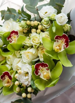 Fresh flowers for any holiday. Close up of a bouquet in green color scheme with roses, eustoma and irises. Concept of floristics and flower arrangements.