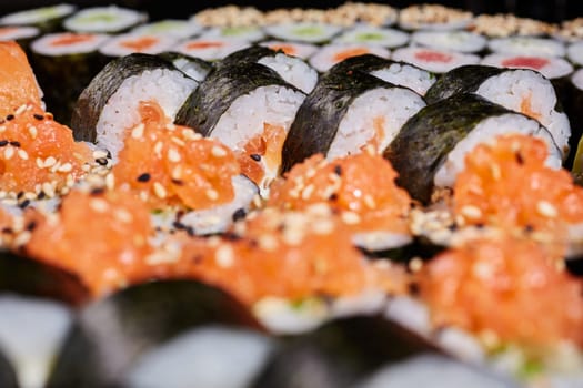 Food background. Close up of Futomaki rolls with different fillings served with sesame seeds. Concept of delicious traditional Japanese cuisine, delicious seafood and restaurant menu.