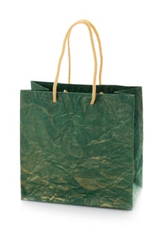 Close up of blank dark green nacre gift bag with raised handles. Package is made of crepe paper. Consumer pack ready for logo design. Isolated on a white background.