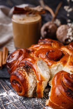 Close up of freshly baked homemade cinnamon buns on wooden table. Christmas sweet buns. New Year. Scandinavian buns. Christmas baking concept.