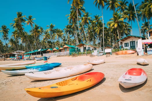 Canacona, Goa, India. Canoe Kayak For Rent Parked On Famous Palolem Beach On Background Tall Palm Tree In Summer Sunny Day.