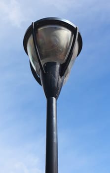 A street lamp, with blue sky in the background.Eine Straßenlaterne, mit blauem Himmel im Hintergrund.