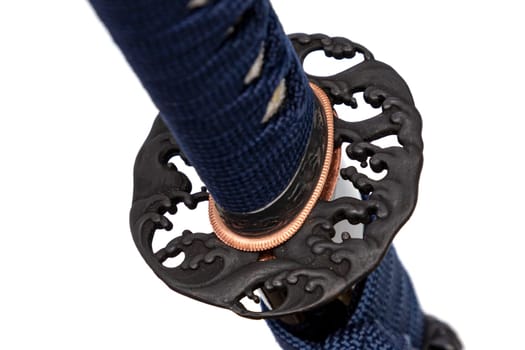 Wave Design Tsuba: Japanese sword hand guard made of steel. Sword hilt and sheath wrapped with navy cord, black scabbard, isolated on white background.