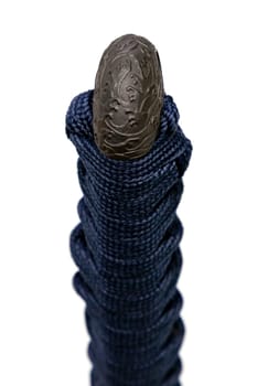 Wave design Kashira : butt cap (or pommel) made of steel on the end of the navy blue silk cord handle Japanese sword isolated in white background. Selective focus.