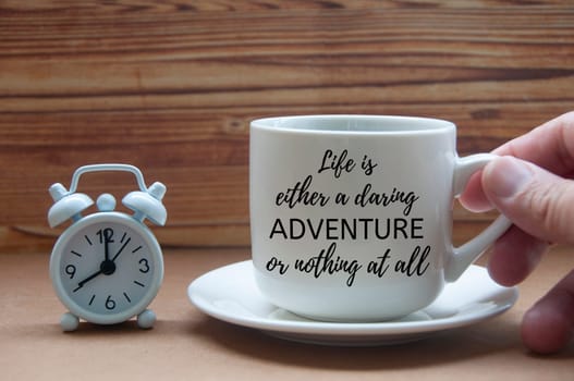 Motivational quote on coffee cup - Life is either a daring adventure or nothing at all. Motivational and inspirational concept.