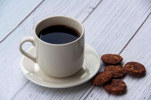 Coffee cup and cookies on wooden floor with customizable space for text or ideas. Copy space.