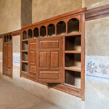 Wooden arabesque ottoman era cupboard with engraved decorations embedded in a grunge wall
