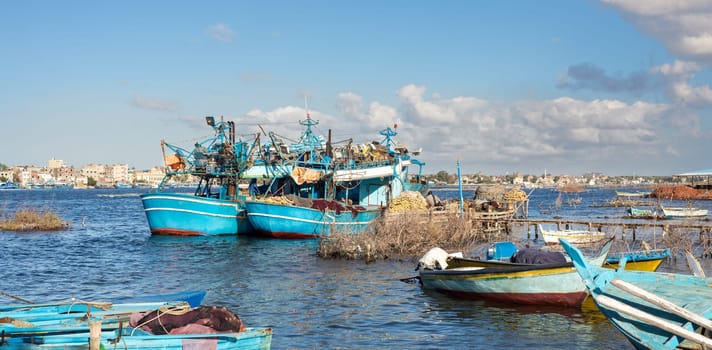 Fishing boats parked at River Nile in cloudy winter day, El Borg district, Rosetta City, Egypt