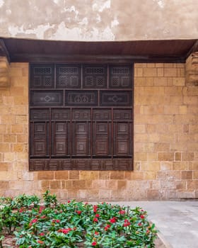 Wooden arabesque window, Mashrabiya, in exterior stone bricks wall of ottoman era old historic El Sehemy building, Moez Street, Cairo, Egypt