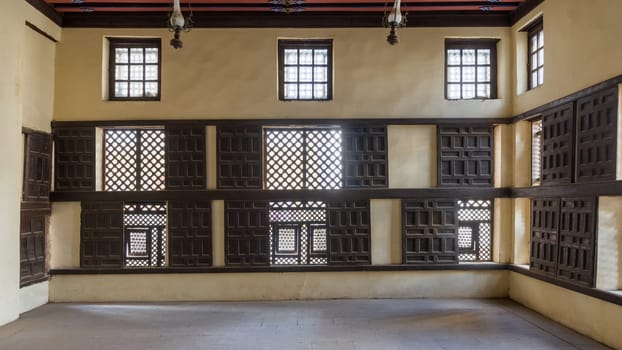 Interior wall with decorated lattice wooden windows, Mashrabiya, and sliding wooden shutters at ottoman era Amasely historic house, Rosetta City, Egypt