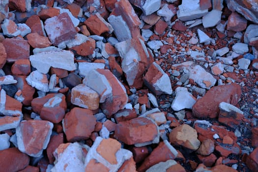 grey concrete stone with brocken red bricks on the background as a ruins of building backdrop.