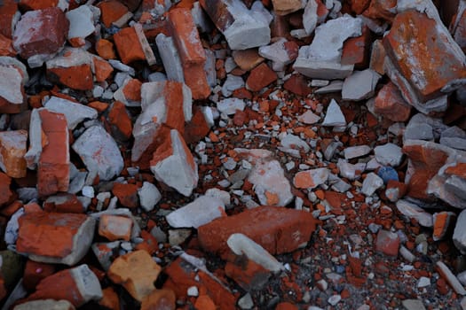 grey concrete stone with brocken red bricks on the background as a ruins of building backdrop.