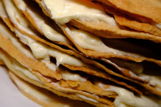 Puff pastry cake Napoleon layers closeup texture with white cream inside.