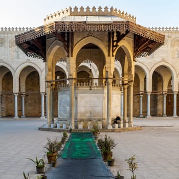 Cairo, Egypt- January 16 2016: Ablution fountain at the courtyard of public historic mosque of Sultan Al Moaayad with background of arched corridors surrounding the courtyard
