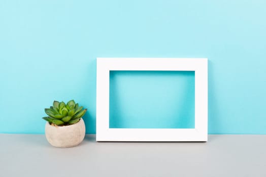 Home interior poster mock up with wooden frame, cactus in a pot, colored wall background, copy space for text and pictures