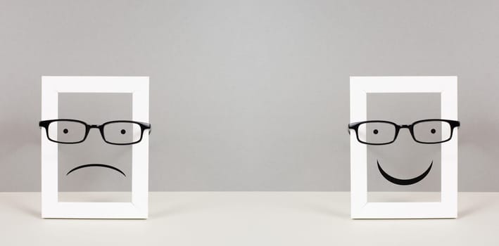 Frame with a sad and a happy face with eyeglasses, mental health concept, positive and negative mindset, depression, support and evaluation symbol, emotion