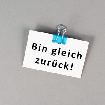 I will be back soon is standing in german language on a paper, taking a break, leaving a message on the desk