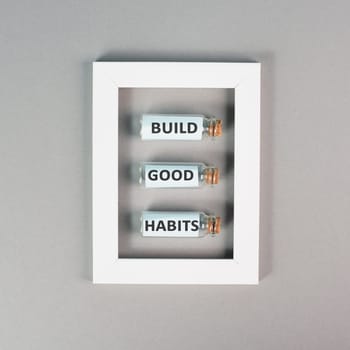 The words build good habits are standing on glass bottles in a frame, change lifestyle, healthy and positive attidude, motivation concept