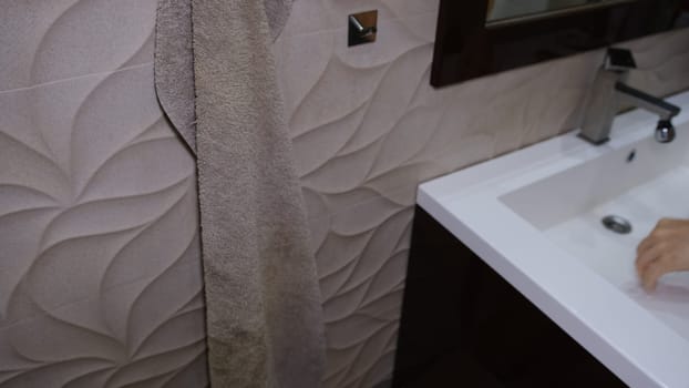 A man drying his hands in the bathroom after washing them with soap to avoid getting infected with coronavirus. Covid concept