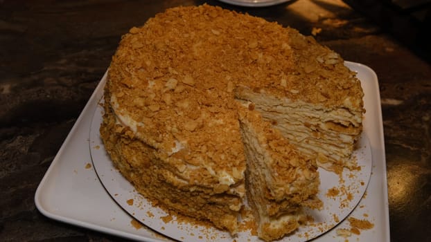man's hands take a piece of cake Napoleon with the inscription Love. Delicious homemade holiday cake. Top view. Close-up
