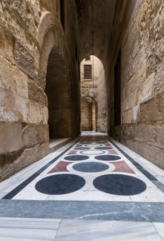 Vaulted passage leading to the Courtyard of Sultan Qalawun mosque with geometrical pattern colorful marble floor, Moez Street, Old Cairo, Egypt
