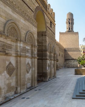 Entrance of public historic Al Hakim Mosque known as The Enlightened Mosque with Minaret in the far end, located in Moez Street, Old Cairo, Egypt